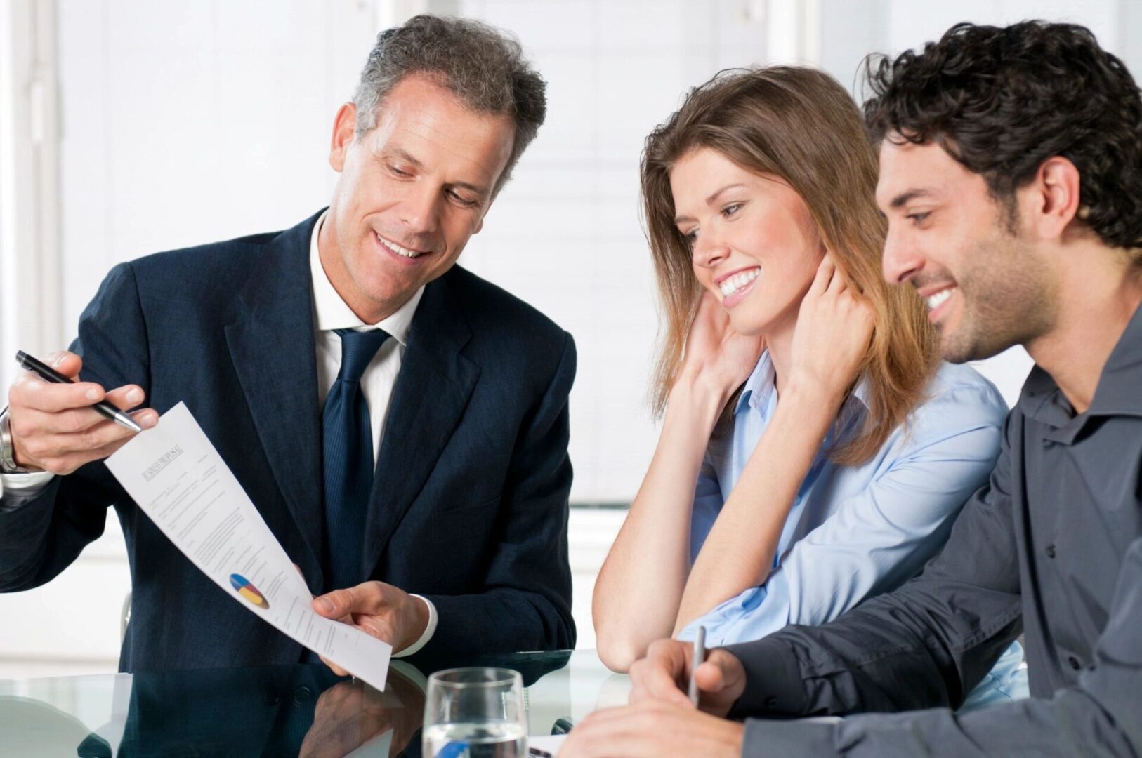 insurance agent signing a term life insurance application with young couple 